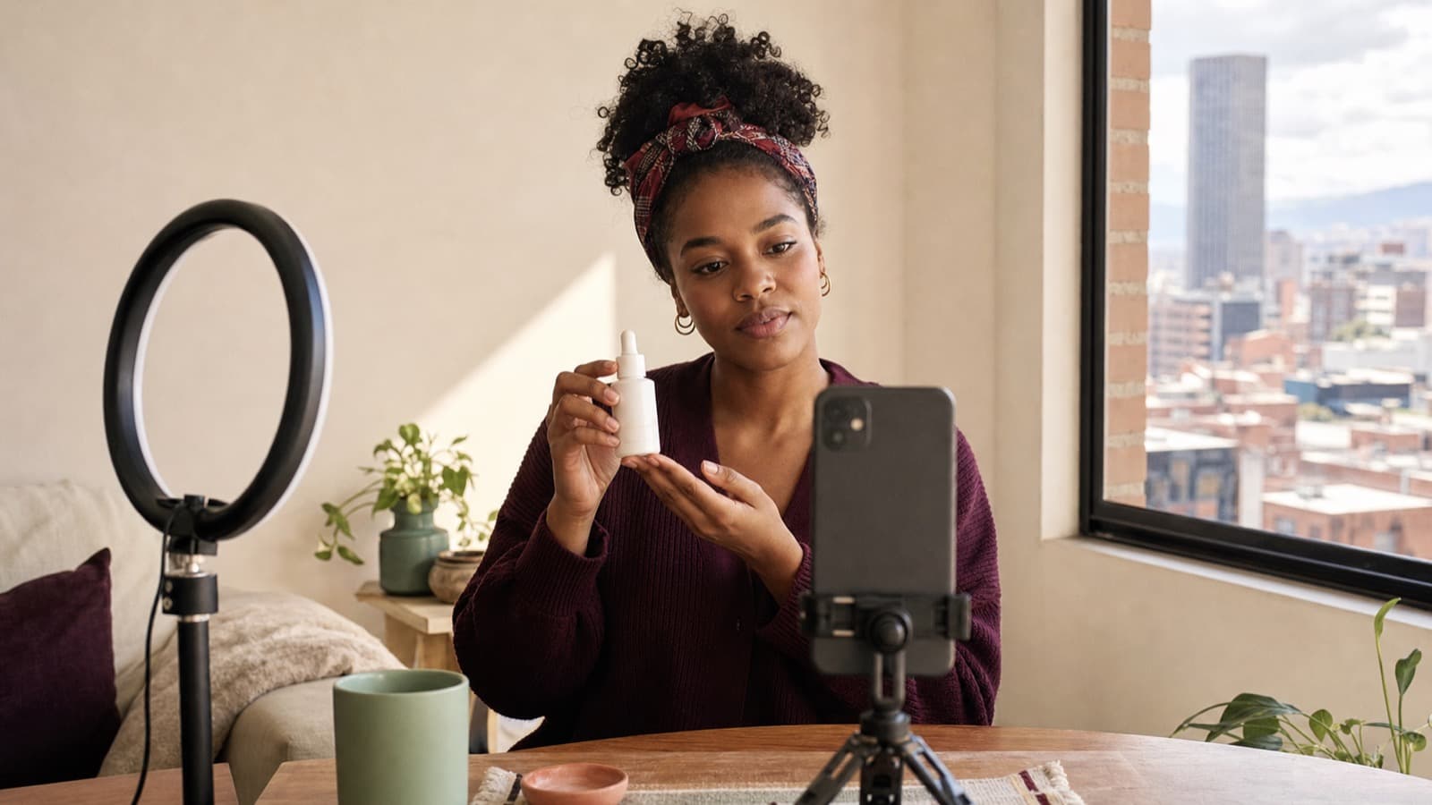 Creadora UGC afrocolombiana graba una demostración de producto con su celular en un apartamento de Bogotá
